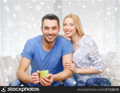 love, family, drinks and people concept - smiling couple with cup of tea or coffee at home