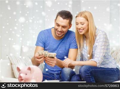 love, family, finance, money and happiness concept - smiling couple counting money with piggybank on table at home