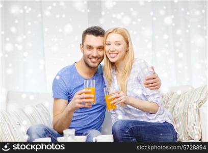 love, family, healthy lifestyle and people concept - smiling happy couple drinking orange or carrot juice at home