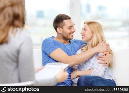 love, family, phychology and happiness concept - young couple hugging at psychologist office