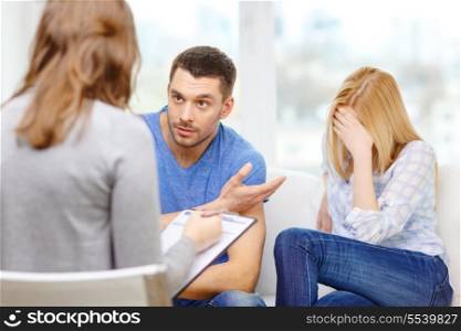 love, family, phychology and relationship problems concept - young couple with a problem at psychologist office