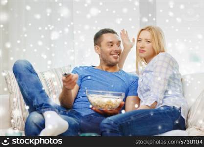 love, family, technology, entertainment and people concept - smiling couple watching tv and lying on sofa at home