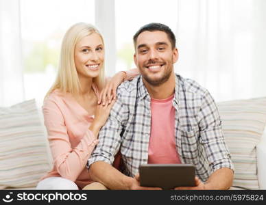 love, family, technology, internet and happiness concept - smiling happy couple with tablet pc computer at home