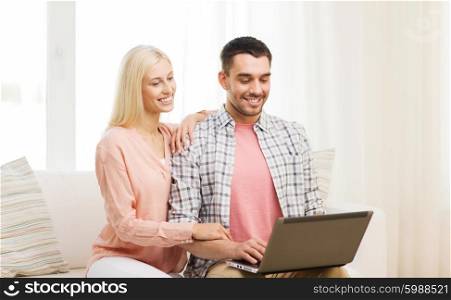 love, family, technology, internet and happiness concept - smiling happy couple with laptop computer at home