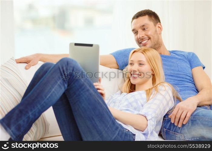 love, family, technology, internet and happiness concept - smiling happy couple witl tablet pc computer at home