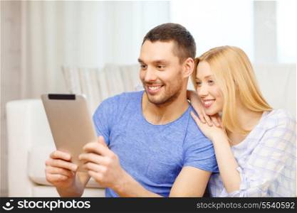 love, family, technology, internet and happiness concept - smiling happy couple witl tablet pc computer sitting on the floor at home