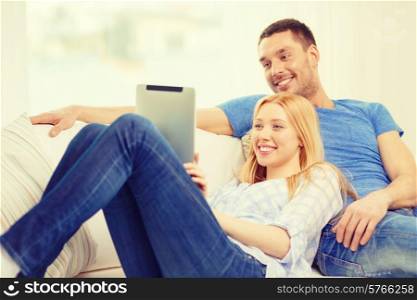 love, family, technology, internet and happiness concept - smiling happy couple witl tablet pc computer at home