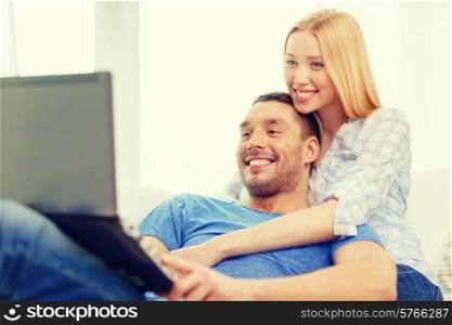 love, family, technology, internet and happiness concept - smiling happy couple witl laptop computer at home