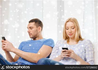 love, family, technology, internet and people concept - couple with smartphones at home