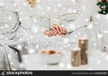 love, family, winter holidays and happiness concept - close up of happy couple sitting under plaid at home for christmas