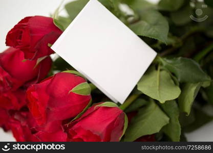 love, flowers, valentines day and holidays concept - close up of red roses bunch and letter or note. close up of red roses and letter or note