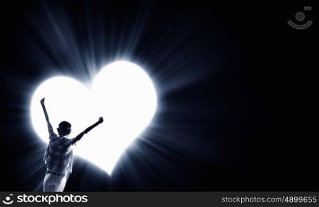 Love forever. Rear view of woman with hands up in light of love