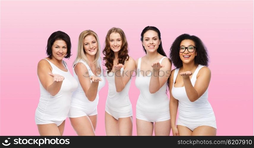 love, friendship, beauty, body positive and people concept - group of happy plus size women in white underwear sending blow kiss over pink background
