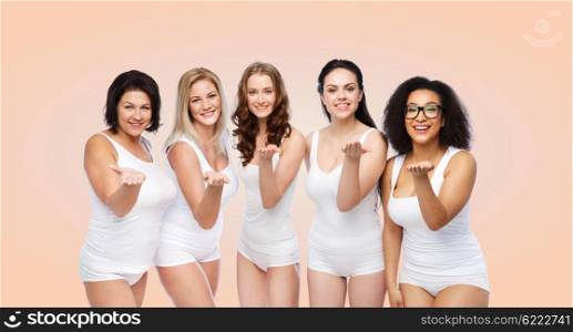 love, friendship, beauty, body positive and people concept - group of happy plus size women in white underwear sending blow kiss over beige background