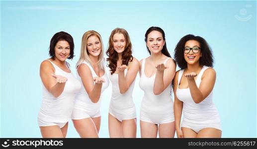 love, friendship, beauty, body positive and people concept - group of happy plus size women in white underwear sending blow kiss over blue background