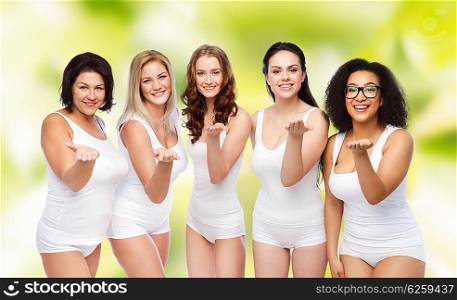 love, friendship, beauty, body positive and people concept - group of happy plus size women in white underwear sending blow kiss over green natural background