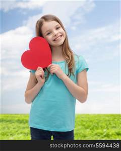 love, happiness and people concept - smiling little girl with red heart