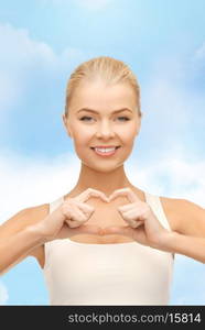 love, happiness and people concept - smiling woman showing heart shape gesture