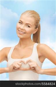 love, happiness and people concept - smiling woman showing heart shape gesture