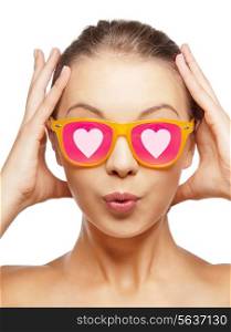 love, happiness, valentines day, face expressions and people concept - portrait of surprised teenage girl in pink sunglasses with hearts
