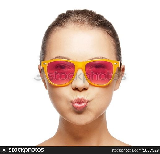 love, happiness, valentines day, face expressions and people concept - portrait of teenage girl in pink sunglasses blowing kiss