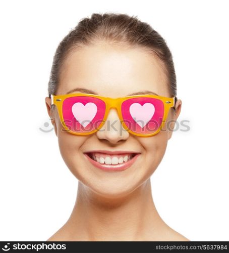 love, happiness, valentines day, face expressions and people concept - portrait of smiling teenage girl in pink sunglasses with hearts