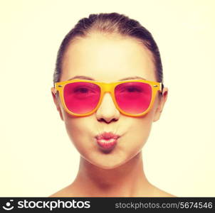 love, happiness, valentines day, face expressions and people concept - portrait of teenage girl in pink sunglasses blowing kiss