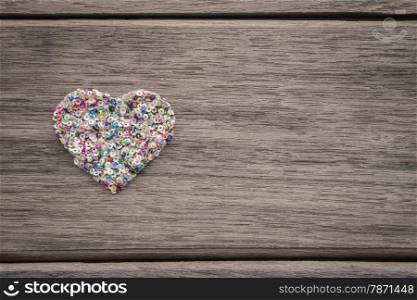 Love heart shape from colorful glitter on left side of wood background with space for text, valentine&rsquo;s day symbol