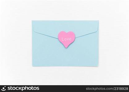 Love Letter. Blue closed envelope and pink heart with text LOVE on white background. Top view Flat lay Template for your text. Valentines day, Mothers day, Womens day greeting card.. Love Letter. Blue closed envelope and pink heart with text LOVE on white background. Top view Flat lay Template for your text. Valentines day, Mothers day, Womens day greeting card