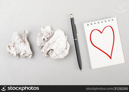 love letter. crumpled wads and notebook with heart picture