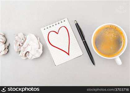 love letter. crumpled wads, notebook with heart picture and cup