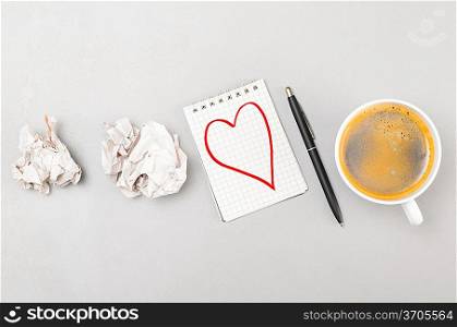 love letter. crumpled wads, notebook with heart picture and cup