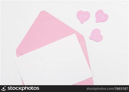 Love Letter. Pink envelope with white blank card and hearts on white background. Top view Flat lay Mockup for your text. Valentines day, Mothers day, Womens day greeting card.. Love Letter. Pink envelope with white blank card and hearts on white background. Top view Flat lay Mockup for your text. Valentines day, Mothers day, Womens day greeting card