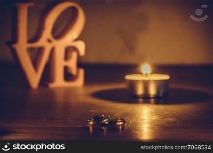 love letters on white background on the left wiht two rings and candle