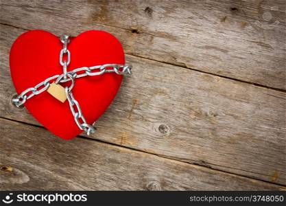 Love lockdown : heart shape with chains on wooden background