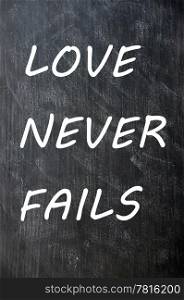 Love Never Fails written on a smudged chalkboard