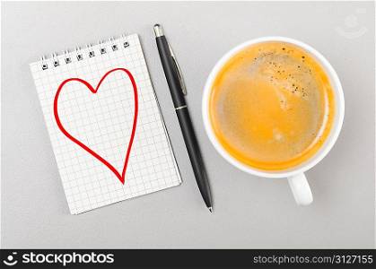 love. notebook with heart picture and cup on gray