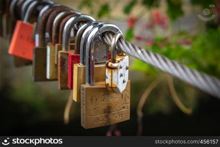 Love padlocks on a cable on a bridge in Valkenburg in the summer
