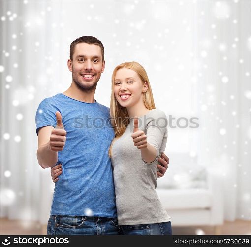 love, people and family concept - smiling couple snowing thumbs up gesture and hugging at home