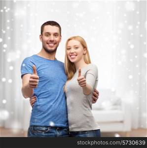 love, people and family concept - smiling couple snowing thumbs up gesture and hugging at home