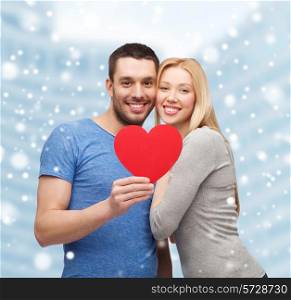 love, people and family concept - smiling couple with red paper heart shape hugging over snow and city buildings background