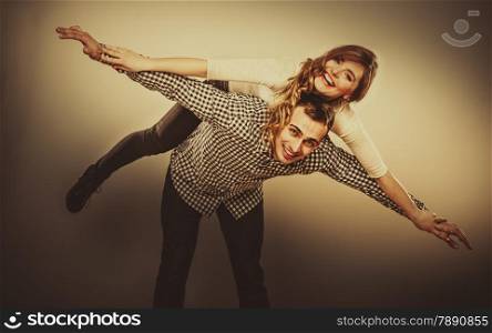 Love people and happiness oncept. Smiling young couple having fun, man giving piggyback ride to woman