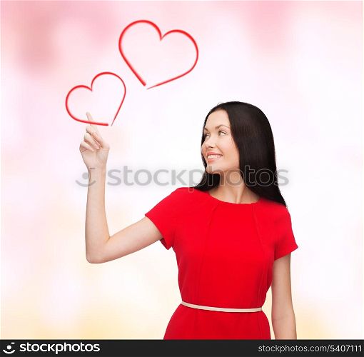 love, relationship and happiness concept - attractive young woman in red dress pointing her finger at hearts
