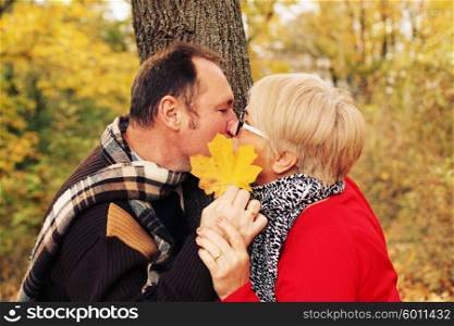 Love, relationship, family, age, tourism, travel and people concept - close up of couple kissing in autumn park