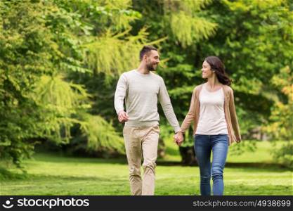 love, relationship, family and people concept - happy couple walking in summer park. happy couple walking in summer park
