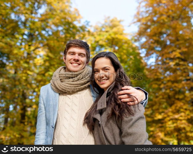 love, relationship, family and people concept - smiling couple hugging in autumn park