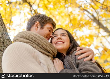 love, relationship, family and people concept - smiling couple hugging in autumn park