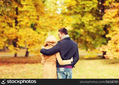 love, relationship, family and people concept - smiling couple hugging in autumn park from back