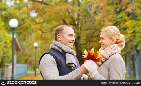 love, relationship, family and people concept - smiling couple in autumn park. smiling couple in autumn park