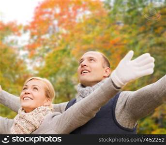 love, relationship, family and people concept - smiling couple in autumn park. smiling couple in autumn park
